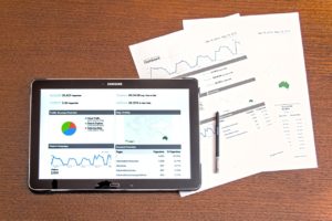 tablet with Google Analytics graphs next to papers