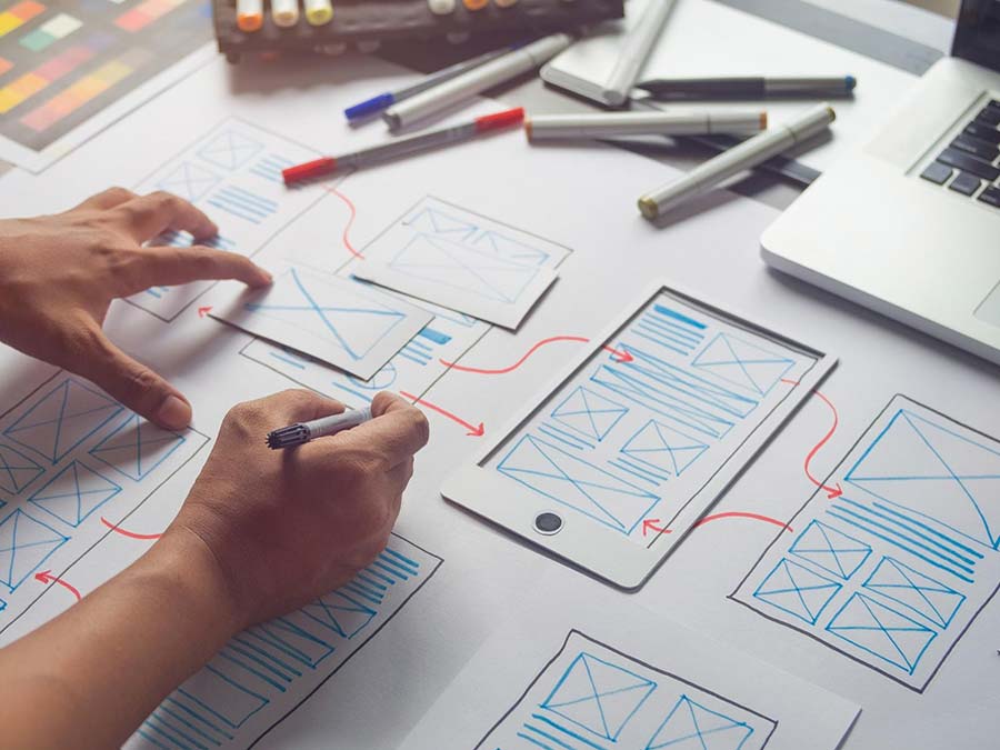 An image of wireframes being drawn by a person for website UX design.